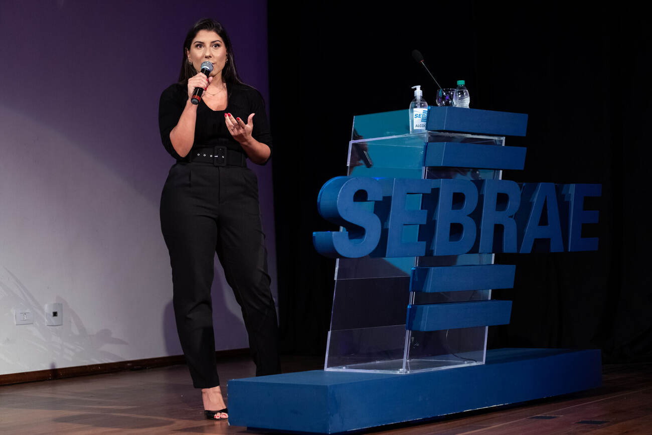Palestra em auditório com projeção Sebrae ao fundo